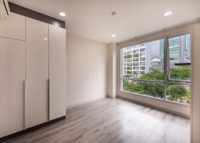 Bright bedroom with large window and built-in wardrobe