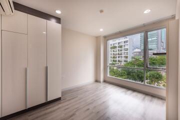 Bright bedroom with large window and built-in wardrobe