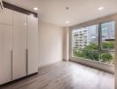 Bright bedroom with large window and built-in wardrobe