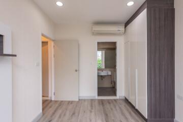 Modern bedroom with wooden flooring and built-in wardrobe