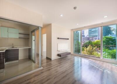 Modern open-plan living room with large windows and adjacent kitchen