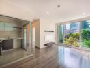 Modern open-plan living room with large windows and adjacent kitchen