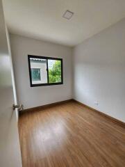 Empty bedroom with wooden flooring and window