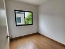 Empty bedroom with wooden flooring and window