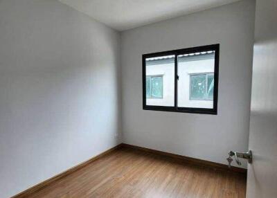 Empty bedroom with wood flooring and window