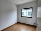 Empty bedroom with wood flooring and window