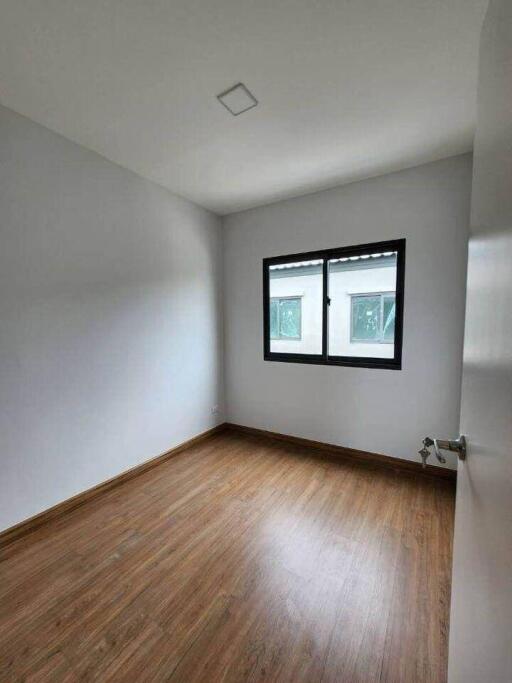 Empty bedroom with wood flooring and window