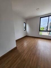 Spacious empty bedroom with large windows and hardwood floors