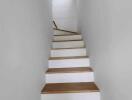 Modern wooden staircase with white walls