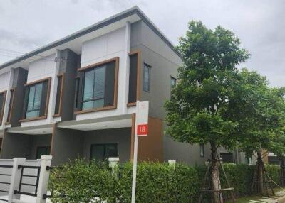 Exterior view of a modern two-story townhouse with greenery