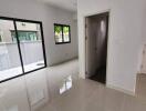 Bright living room with large windows and a door.