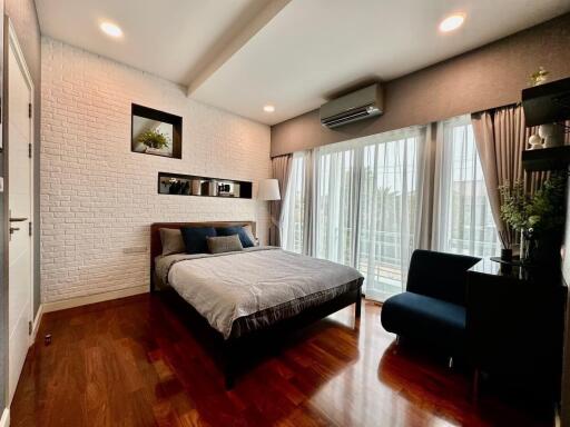 Modern bedroom with large windows and hardwood floors