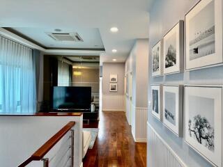 Upstairs hallway with wall art and view of family room