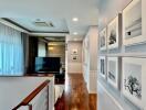 Upstairs hallway with wall art and view of family room