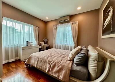 Spacious bedroom with large windows and wooden floor