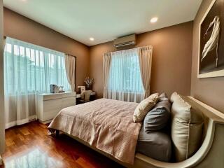 Spacious bedroom with large windows and wooden floor