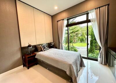 Modern bedroom with large window and garden view