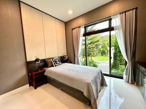 Modern bedroom with large window and garden view