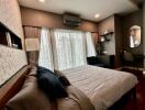 Modern bedroom with bed, air conditioner, desk, and large window