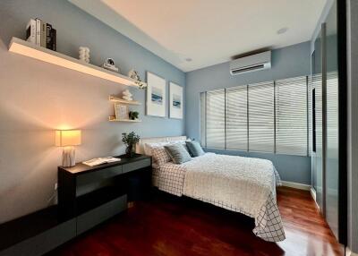 Well-lit bedroom with wooden flooring and modern decor