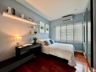 Well-lit bedroom with wooden flooring and modern decor