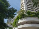 High-rise residential building with green landscaping and covered parking