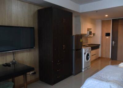 Bedroom with wardrobe, TV, and kitchenette