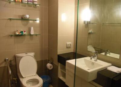 Modern bathroom with toilet, sink, and shelves