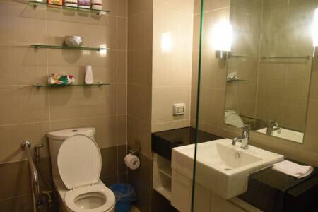 Modern bathroom with toilet, sink, and shelves