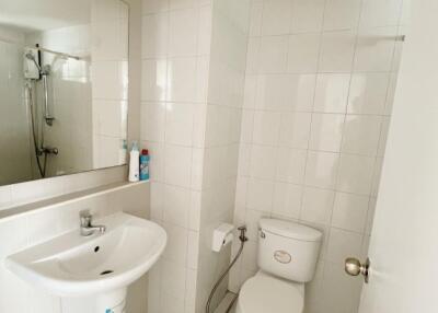 Clean white bathroom with a toilet, sink, mirror, and shower