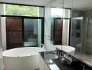 Modern bathroom with double sinks, large bathtub, and shower