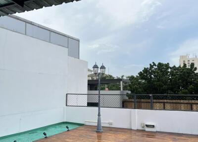 Rooftop area with wooden deck and light post