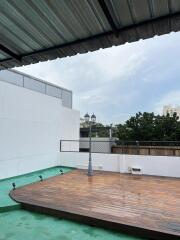 Rooftop area with wooden deck and light post