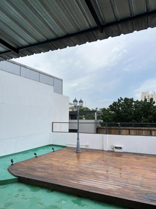 Rooftop area with wooden deck and light post