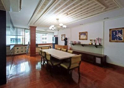 Spacious dining room with elegant table and chairs, decorative ceiling, and large windows.