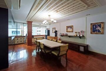 Spacious dining room with elegant table and chairs, decorative ceiling, and large windows.