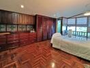 Spacious bedroom with wooden floor and ample storage