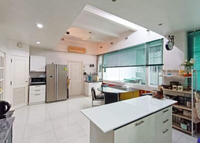 Modern kitchen with white cabinetry, island, and large windows