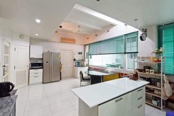 Modern kitchen with white cabinetry, island, and large windows