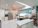 Modern kitchen with white cabinetry, island, and large windows