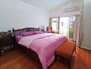 Comfortable bedroom with double bed, wooden flooring and natural light