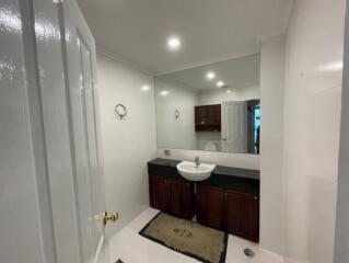 Modern bathroom with large mirror and wooden cabinets