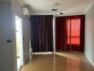 Living room with wooden floor and large curtained windows