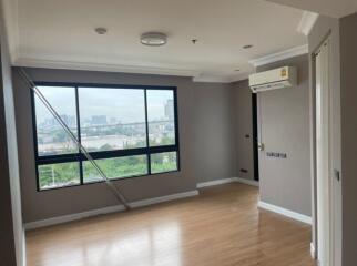 Spacious living room with large window and wooden flooring