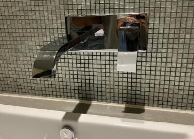 Modern bathroom faucet with tiled backsplash