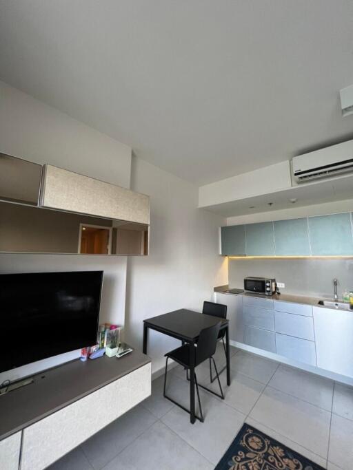 Living area with television, dining table, and kitchen