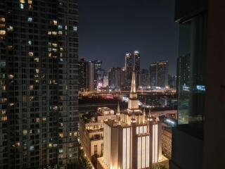 Night view of urban buildings with illuminated tower.