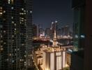 Night view of urban buildings with illuminated tower.