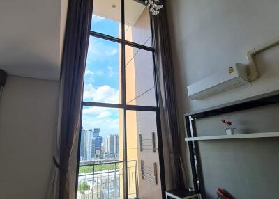 Modern living room with tall ceiling, large window and city view