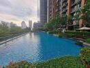 Outdoor swimming pool with greenery and high-rise buildings